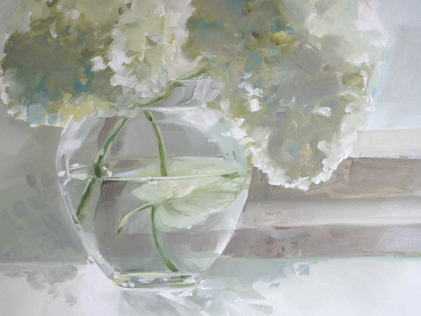 Hydrangeas beside a glass vase